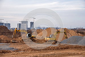 Group of the excavators for dig ground trenching at a construction site for foundation and installing storm pipes. Backhoe digging