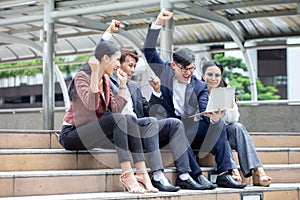 Group of excited asian business people Celebrating of successful with good news by laptop computer put hands up achievement on