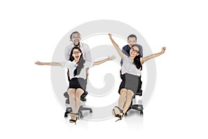 Group of excited business people racing on chairs