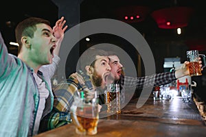 Group of excited friends in beer pub watching sports match