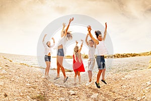 Excited teens jumping and having fun on the beach