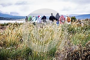 Group of explorers walking in Isla Martillo to visit penguins, t photo