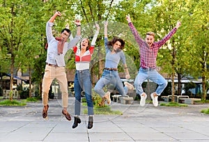 Group of exuberant young friends cheering and leaping in air