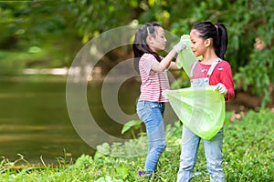 Group family asian children collecting garbage and plastic on the river to dumped into the trash for volunteer charity save enviro