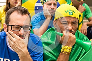 Group of fans watching a match and cheering brazilian team. photo