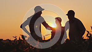 A group of farmers in the field, shaking hands. Family Agribusiness