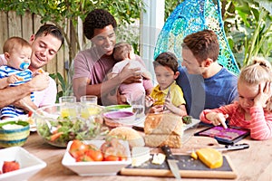 Group Of Fathers With Children Enjoying Outdoor Meal At Home