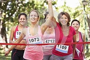 Group Of Female Athletes Completing Charity Marathon Race