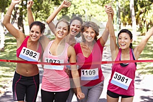 Group Of Female Athletes Completing Charity Marathon Race