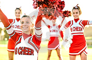 Group of female cheerleaders performing outdoors at university campus - Sport concept of cheerleading team training at high school