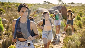 Group Of Female Friends With Backpacks On Vacation On Hike Through Countryside Next To Sea