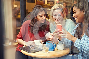 Group Of Female Friends In CafÃ¯Â¿Â½ Using Digital Devices
