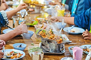 Group of female friends enjoy eating with acacia pennata omelette sour soup in fish shape hot pot in the restaurant.