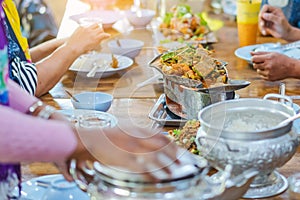 Group of female friends enjoy eating with acacia pennata omelette sour soup in fish shape hot pot in the restaurant.