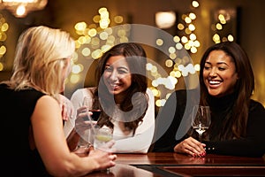 Group Of Female Friends Enjoying Evening Drinks In Bar