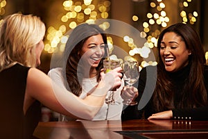 Group Of Female Friends Enjoying Evening Drinks In Bar