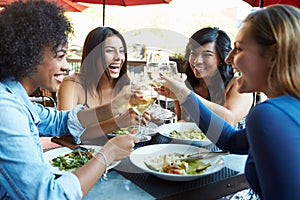 Group Of Female Friends Enjoying Meal At Outdoor Restaurant