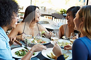 Group Of Female Friends Enjoying Meal At Outdoor Restaurant