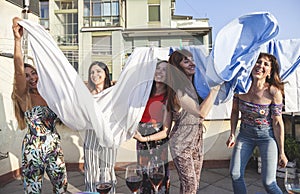 Group of female friends on vacation have fun among the sheets