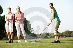 Skupina z žena golfisti odpaliska z 