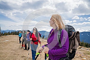 Group of female hikers in mountains during saffron blooming at spring