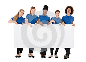 Group Of Female Janitors Holding Billboard