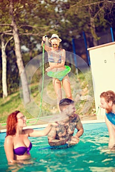 Group of female and male enjoying in swimming pool in nature