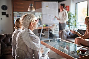 Group of female office staff enjoy watching their female colleague presentation at workplace. Business, office, job