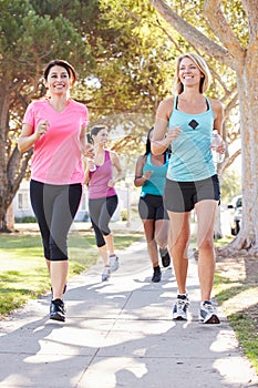 Group Of Female Runners Exercising On Suburban Street