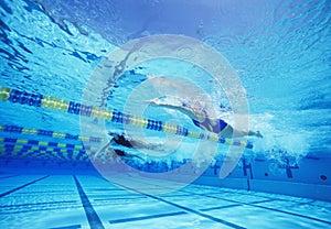 Group of female swimmers racing together in swimming pool