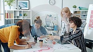 Group of feminists drawing posters and talking discussing equal rights problems in office