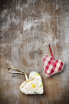 Group of festive hearts from various materials, cloth, wool, wooden, on an old brown concrete or stone background. Selective focus