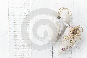 Group of festive hearts from various materials, cloth, wool, wooden, on white wooden background. Selective focus. Vintage