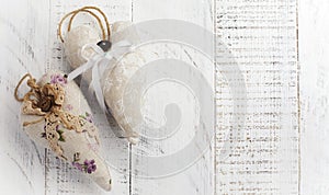 Group of festive hearts from various materials, cloth, wool, wooden, on white wooden background. Selective focus. Vintage