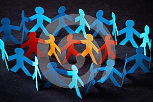 Group of figures of one color surrounded by figures by another color.