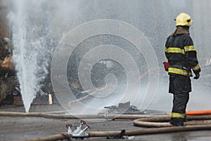 Group of fire men in protective uniform during fire fighting operation in the city streets, firefighters brigade with the fire