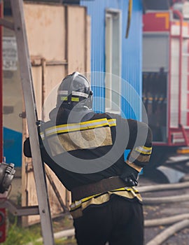 Group of fire men in protective uniform during fire fighting operation in the city streets, firefighters brigade with the fire