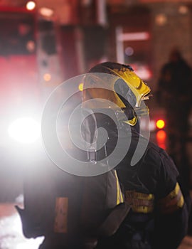 Group of fire men in protective uniform during fire fighting operation in the night city streets, firefighters brigade with the