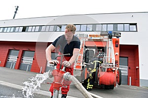 Group of firefighters at the emergency vehicle in the fire station