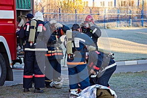 Group of firemen putting on gas masks and preparing for extinguish fire