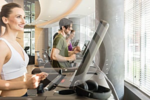 group of fit men and women on treadmill in fitness gym