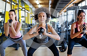 Group of fit people lifting dumbbells during an exercise class at the gym