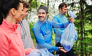 Group of fit people picking up litter in nature, a plogging concept.