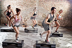 Group of fit people practicing on steeper photo