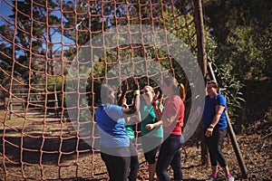 Group of fit women giving high five to each other in the boot camp