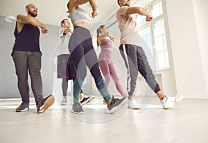 Group of fit young people having a dance or a fitness workout class with an instructor