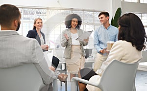 Group of five diverse businesspeople having a meeting in an office at work. Happy mixed race businesswoman reading a