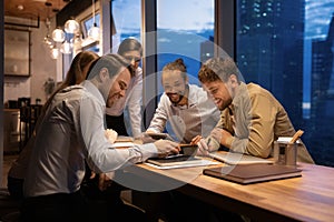 Group of five diverse colleagues have fun at meeting room