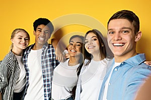 Group of Five Diverse Friends Smiling Together Against Yellow Background