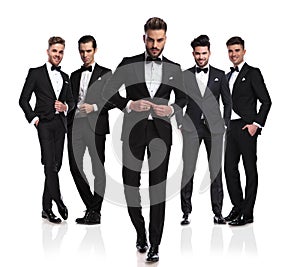 Group of five elegant men with leader buttoning suit photo